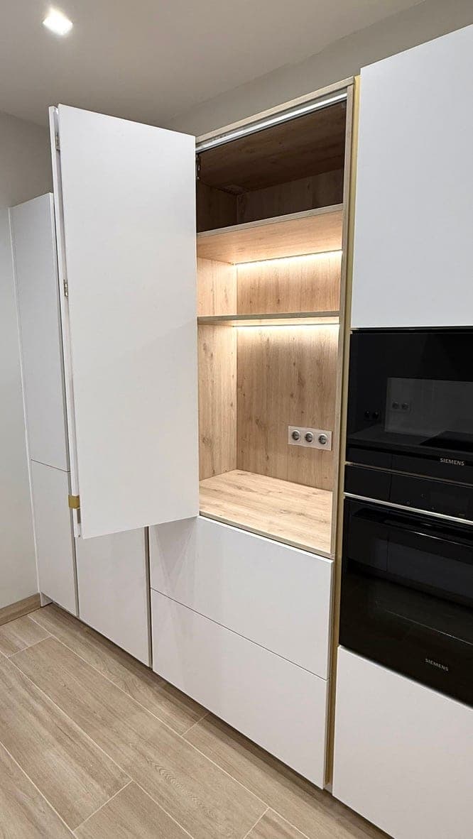 Office oculto tras una puerta, con interior de madera iluminado y tomas de corriente integradas